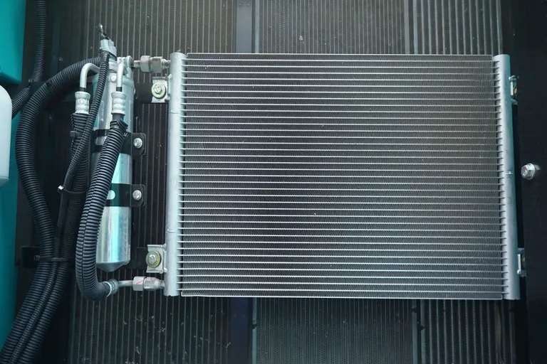 Metal condenser with fins and attached pipes, viewed from above