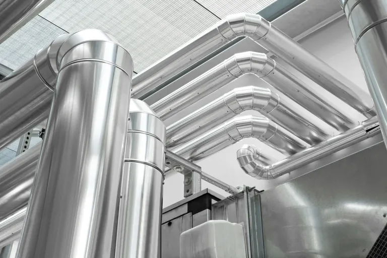 Network of stainless steel industrial ducts inside a technical facility