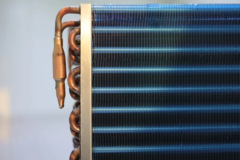 Air conditioning condenser with blue fins and copper tubes on the side